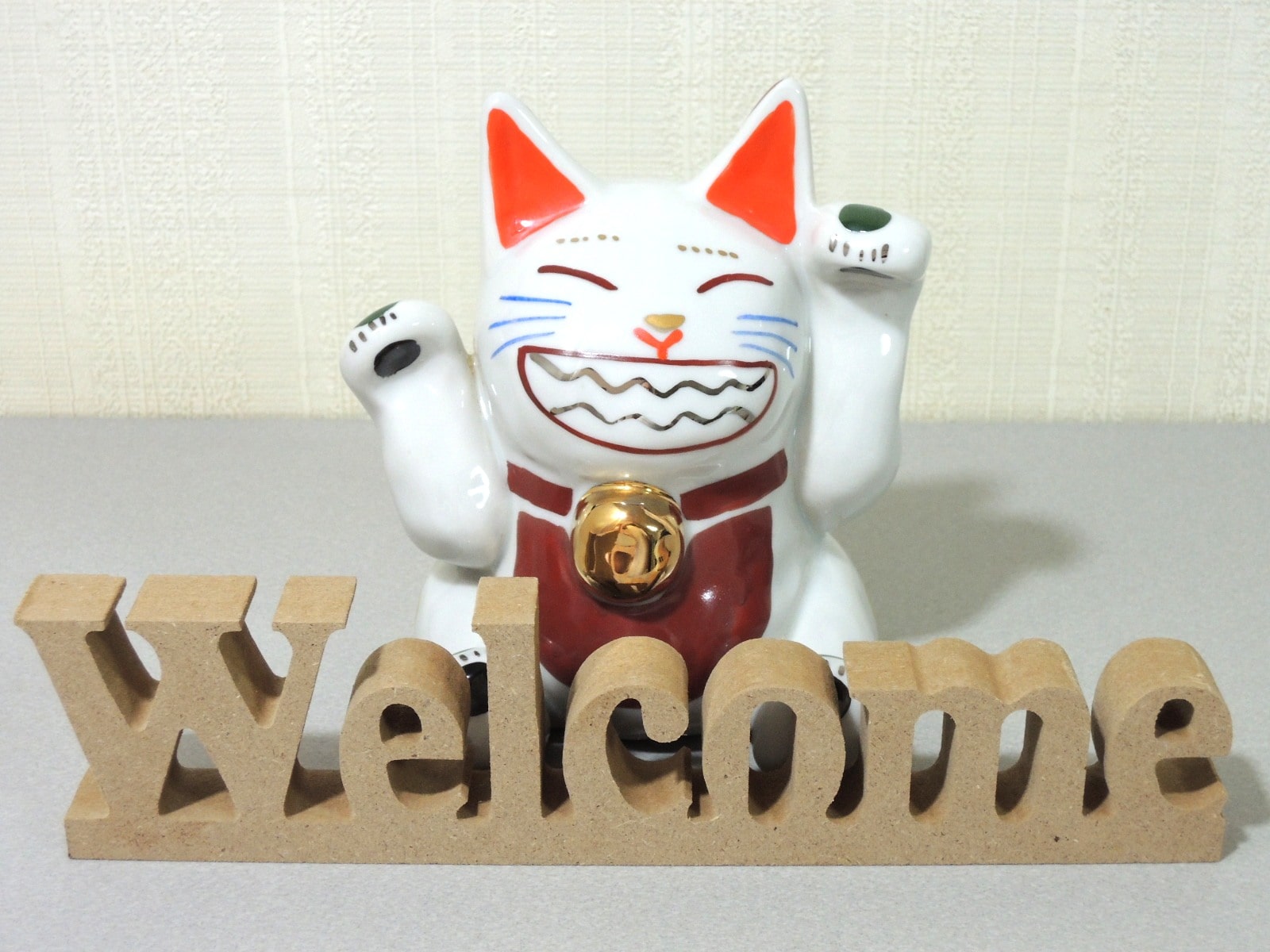 Welcomeの切り抜き文字プレートと招き猫